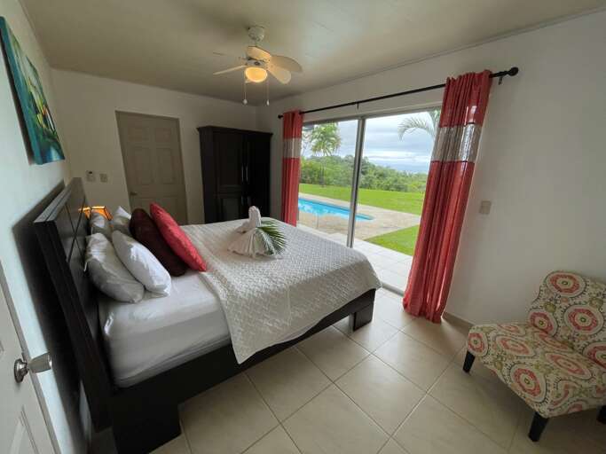 Room With Bed, Armchair, And Sliding Door Leading To Pool Room With Bed, Armchair, And Sliding Door Leading To Pool