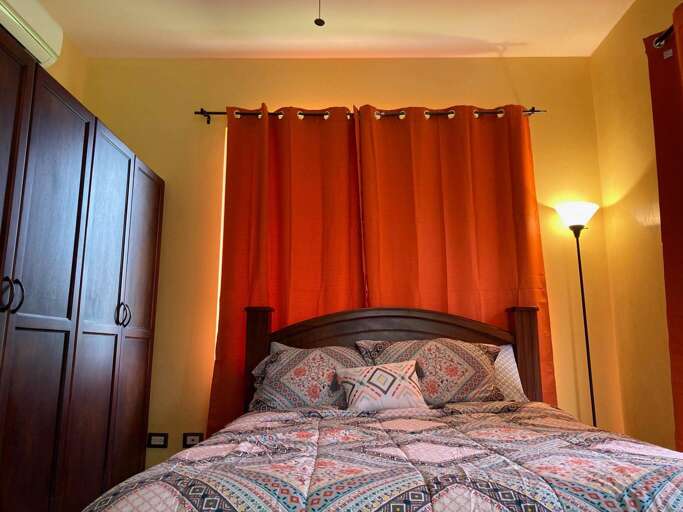 Bedroom With Red Curtains And Patterned Bedding