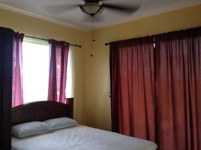 Interior Of A Bedroom With Curtains And A Bed