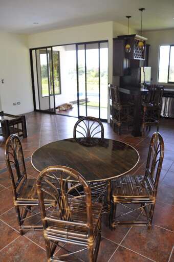 Dining Room Interior With Round Table And Chairs, Tiled Floor, And Sliding Glass Door