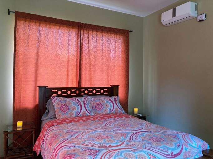 Bedroom With Red Curtains And Patterned Bedding