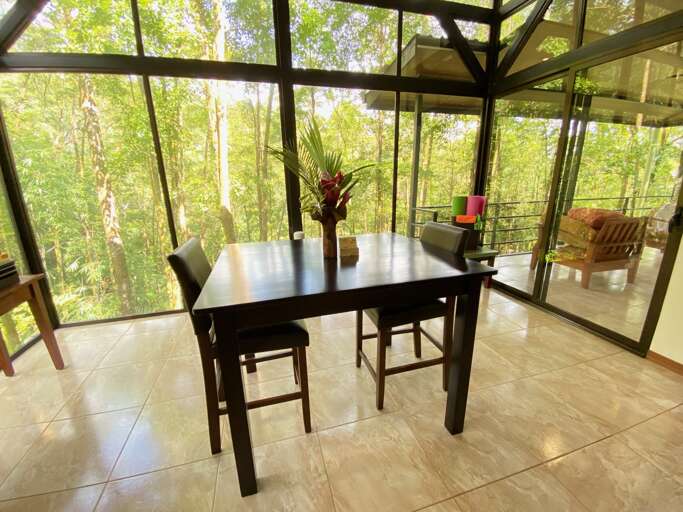 Dining Table In A Room With Large Windows Overlooking Trees Dining Table In A Room With Large Windows Overlooking Trees