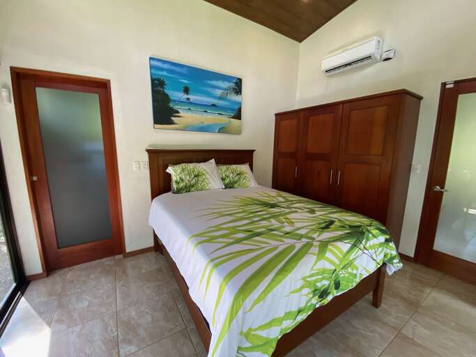 Room With Bed, Beach-themed Painting, And Air Conditioner Room With Bed, Beach-themed Painting, And Air Conditioner