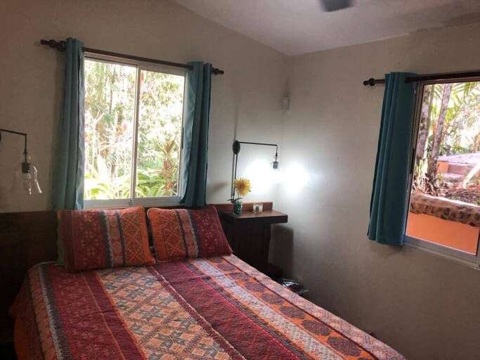 Interior Of A Bedroom With Patterned Bedspread And Green Curtains Interior Of A Bedroom With Patterned Bedspread And Green Curtains