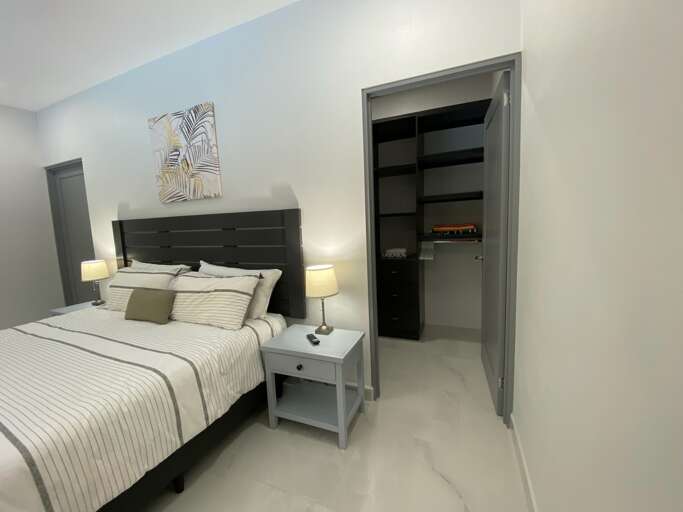 Modern Bedroom With Bed, Nightstands, Lamps, And Open Closet