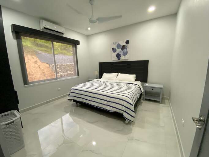 Modern Bedroom With Striped Bedding And Ceiling Fan