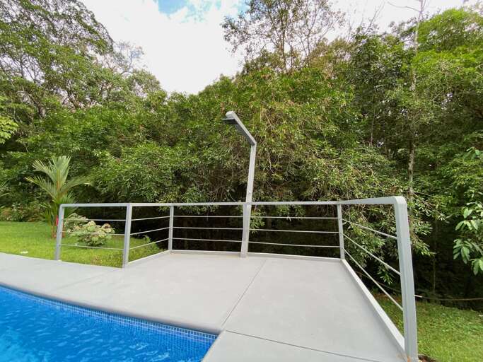 Outdoor Pool With A Railing And Surrounding Trees