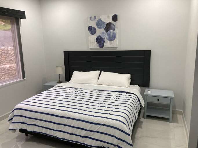 Modern Bedroom With Striped Bedding And Abstract Wall Art