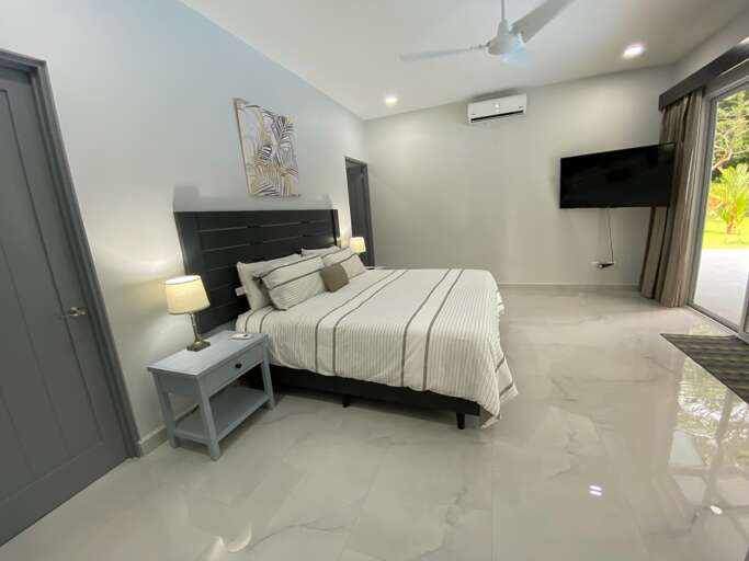 Modern Bedroom With A Double Bed, Nightstands, And Wall-mounted TV