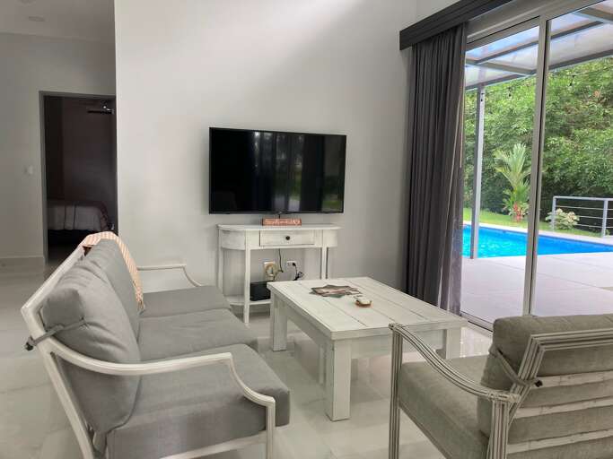 Living Room Interior With Sofa, TV, And Pool View