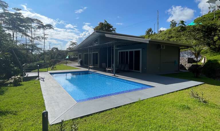 House With Swimming Pool And Lawn Under A Clear Sky