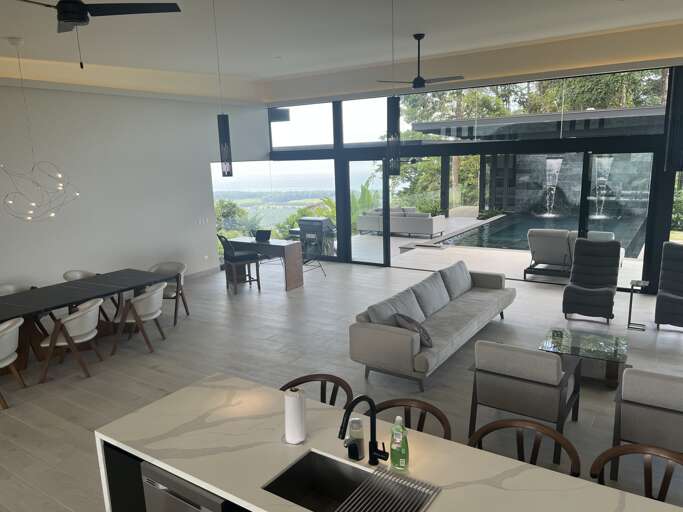 Modern Interior With Kitchen, Dining And Living Area, Large Windows With Outdoor View