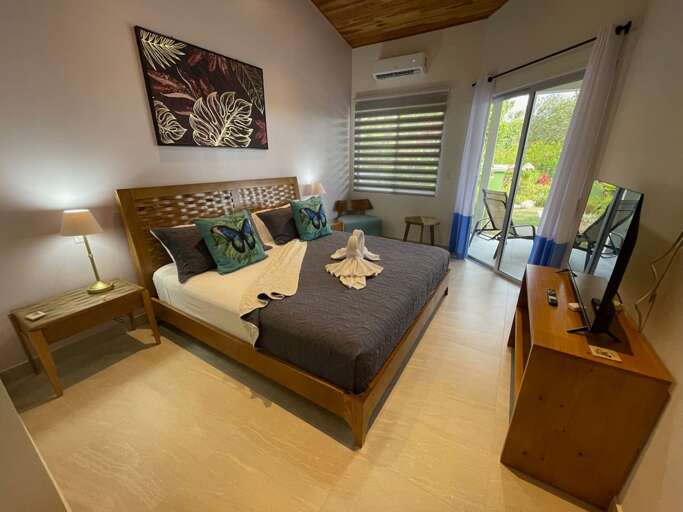 Bedroom With Brown Furnishings, Blue Bedding, And Balcony Access