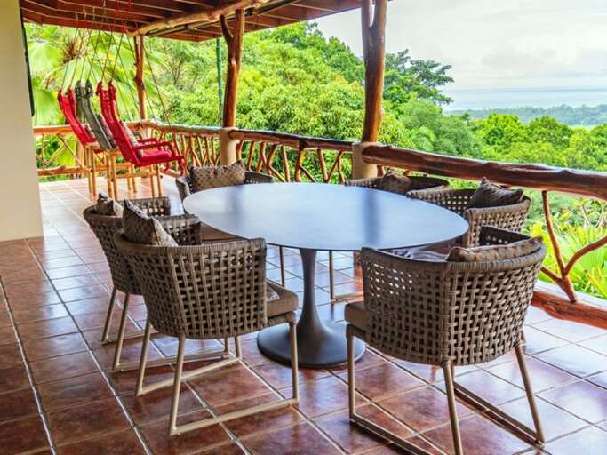 Outdoor Patio With Chairs And Table Overlooking A Scenic View Outdoor Patio With Chairs And Table Overlooking A Scenic View