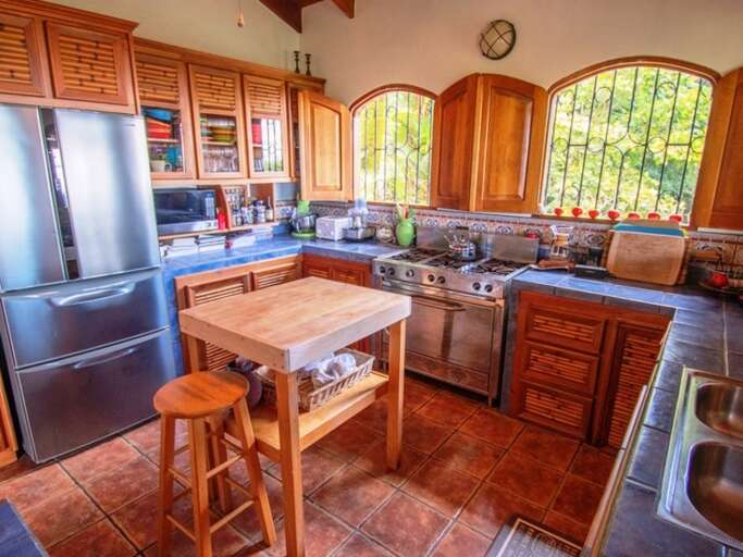 Kitchen Interior With Modern Appliances, Wooden Cabinets, And Arched Windows Kitchen Interior With Modern Appliances, Wooden Cabinets, And Arched Windows
