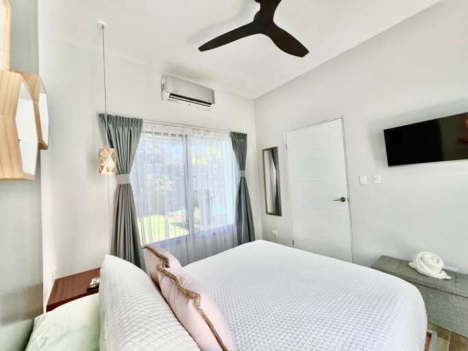 Bright Modern Room With Bed, Ceiling Fan, And Window