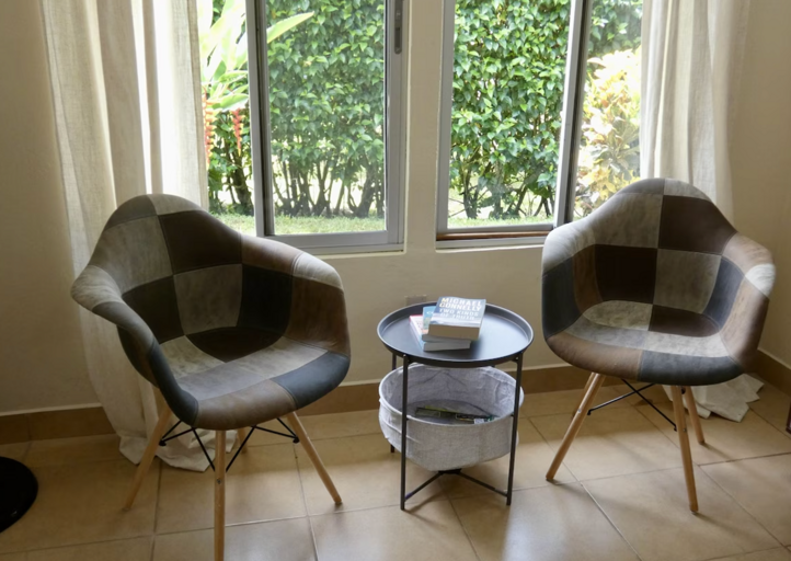 Two Chairs And A Table By A Window With Garden View