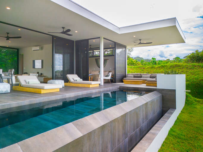 A modern home with a sparkling pool and an inviting outdoor living space, designed for comfort and outdoor enjoyment. A modern home with a sparkling pool and an inviting outdoor living space, designed for comfort and outdoor enjoyment.