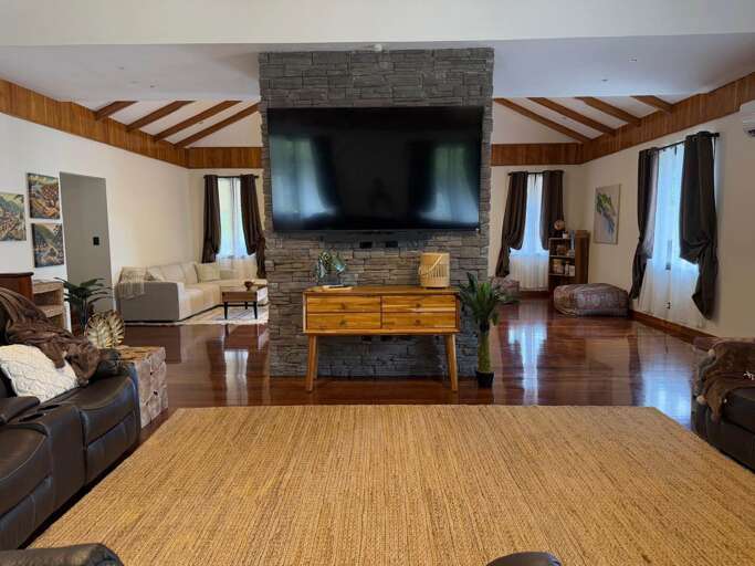 Large TV and living room in Main House on second floor with balcony. Large TV and living room in Main House on second floor with balcony.