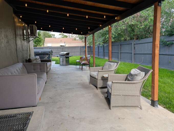 Covered pergola patio: lounge seating, gas grill & string lights