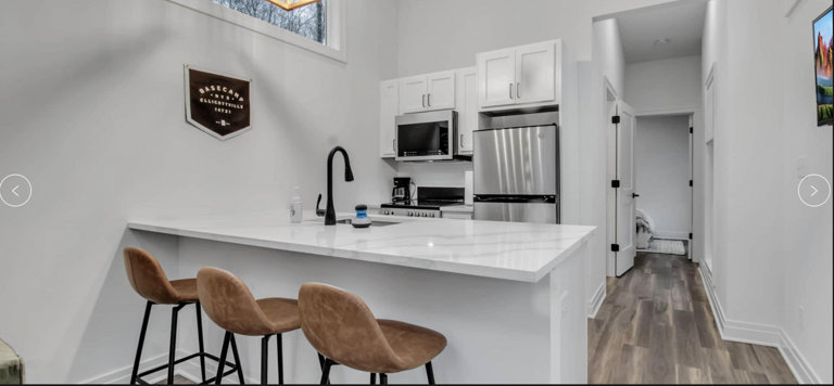 Modern Kitchen Interior With White Cabinets And Bar Stools