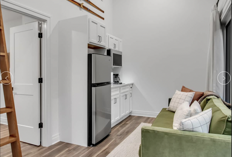 Modern Kitchen With White Cabinets Beside Living Area With Green Sofa Modern Kitchen With White Cabinets Beside Living Area With Green Sofa