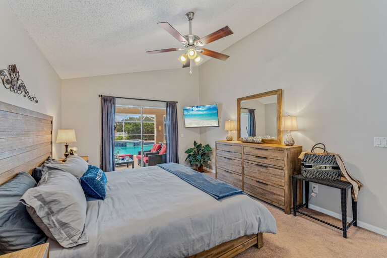 Bedroom Interior With Large Bed, Furniture, And Sliding Door Leading Outside Bedroom Interior With Large Bed, Furniture, And Sliding Door Leading Outside