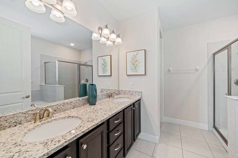 Bathroom with dual sinks and glass enclosed shower