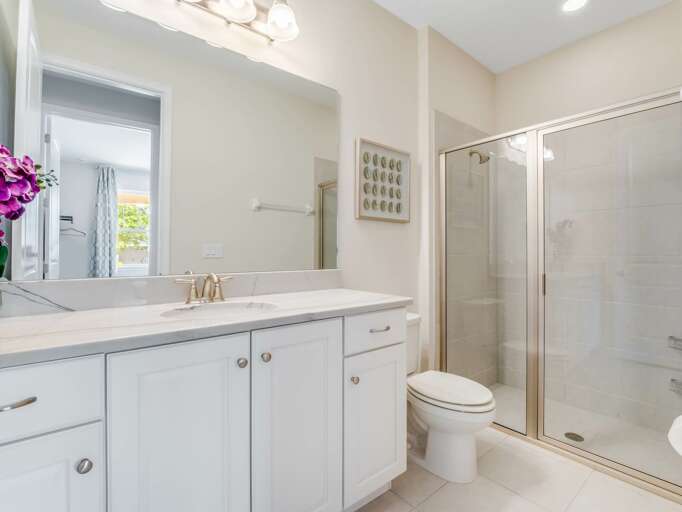 Bathroom with dual sinks and glass enclosed shower