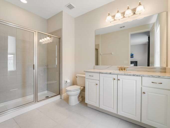 Bathroom with dual sinks and glass enclosed shower