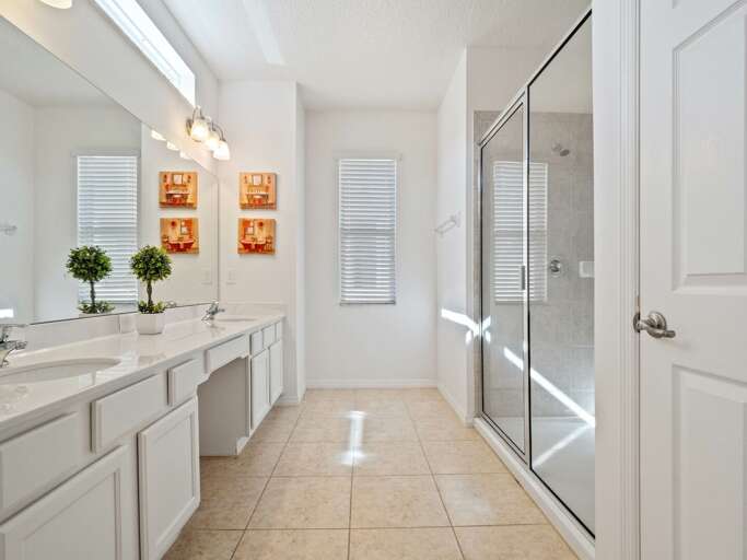 Bathroom with dual sinks and glass enclosed shower