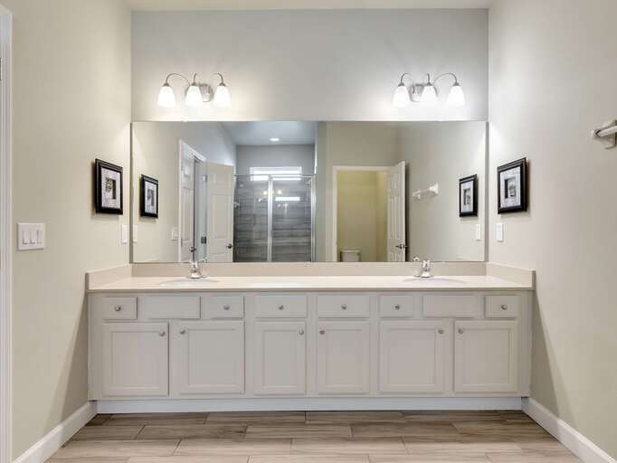 Bathroom with dual sinks and glass enclosed shower
