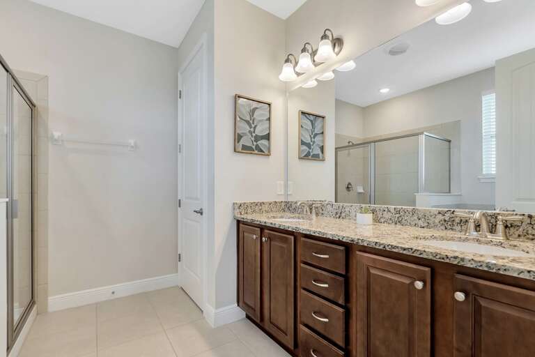Bathroom with dual sinks and glass enclosed shower