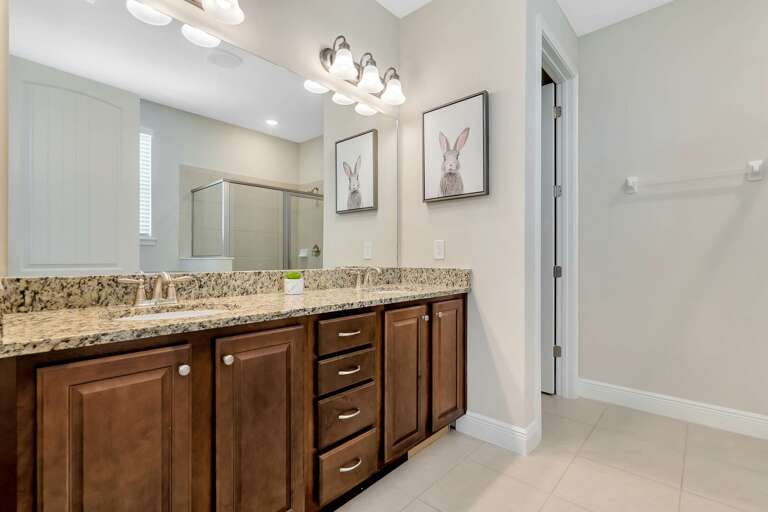 Bathroom with dual sinks and glass enclosed shower