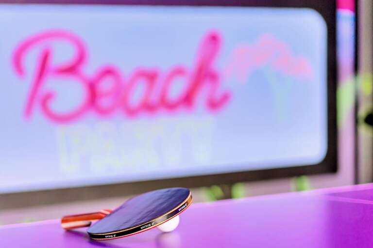 Beach dance party themed game room with foosball and ping pong table