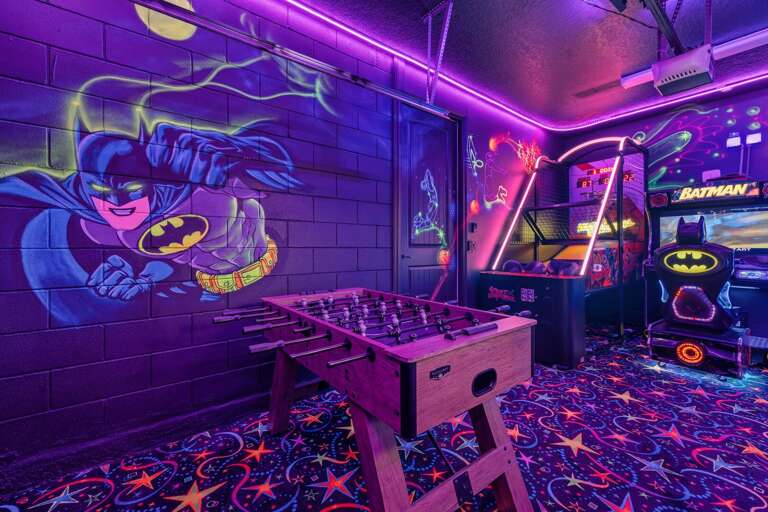 Batman-themed Game Room With Arcade Machines And Foosball Table