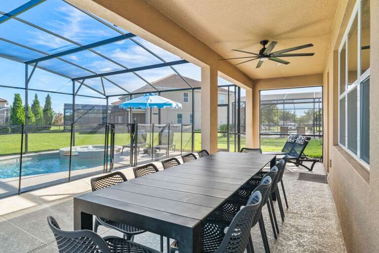 - Covered patio with lounge seating and outdoor dining tables  
- Relax with ceiling fans and poolside access in screened area  
- Orlando villa offering outdoor dining and family gathering