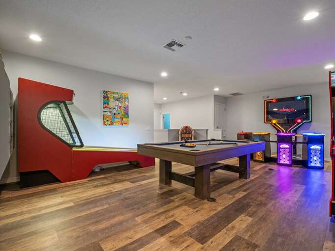 Game room with Skee-Ball, pool table, jukebox, and Pacman arcade