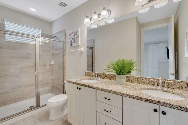 Bathroom with dual sinks and glass enclosed shower Bathroom with dual sinks and glass enclosed shower