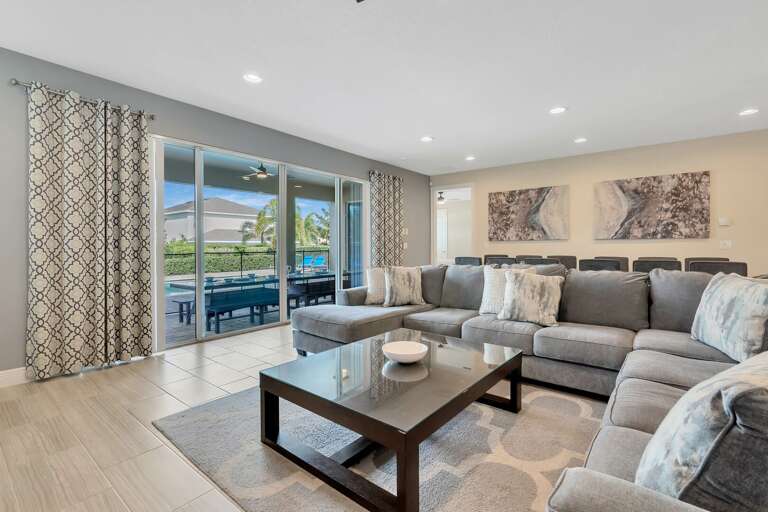 Living area with comfy sectional sofa and access to lanai and pool area Living area with comfy sectional sofa and access to lanai and pool area