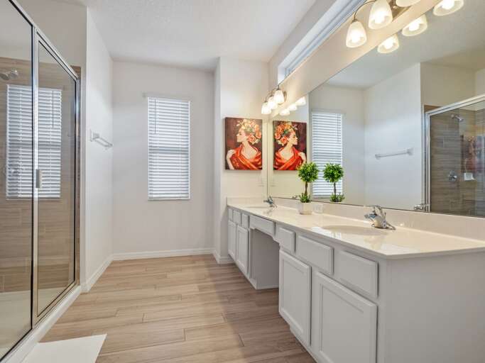 Bathroom with dual sinks and glass enclosed shower