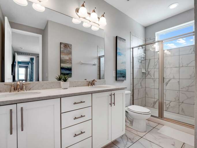 Bathroom with dual sinks and glass enclosed shower Bathroom with dual sinks and glass enclosed shower