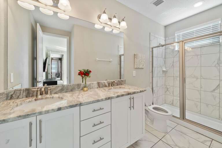 Bathroom with dual sinks and glass enclosed shower Bathroom with dual sinks and glass enclosed shower