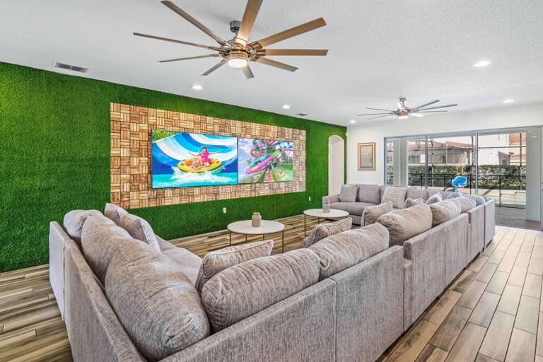 Living area with huge sectional sofa and two 86” TVs