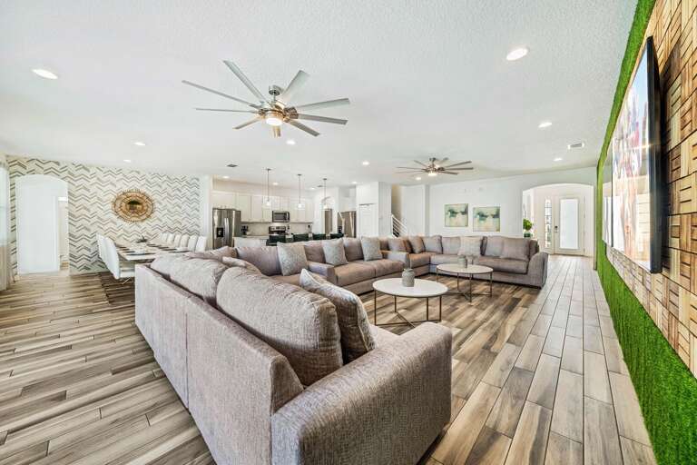 Living area with huge sectional sofa and two 86” TVs