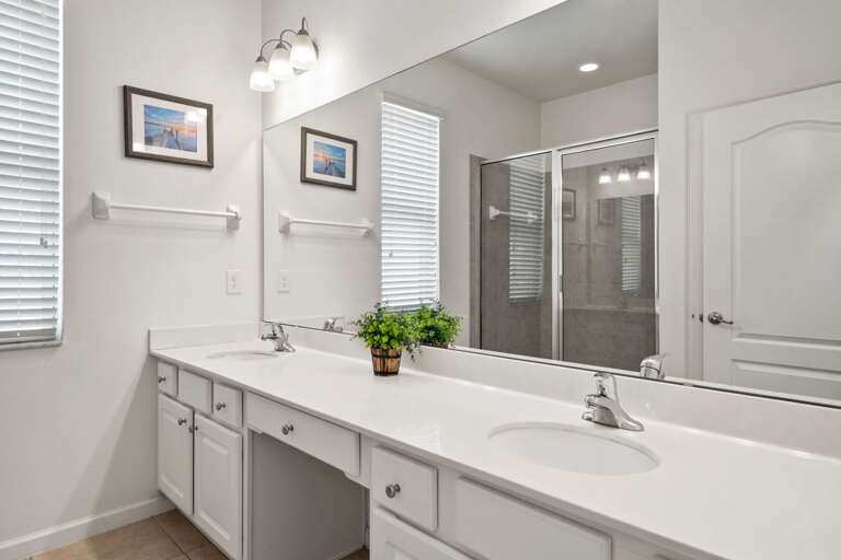 Bathroom with dual sink and glass enclosed shower