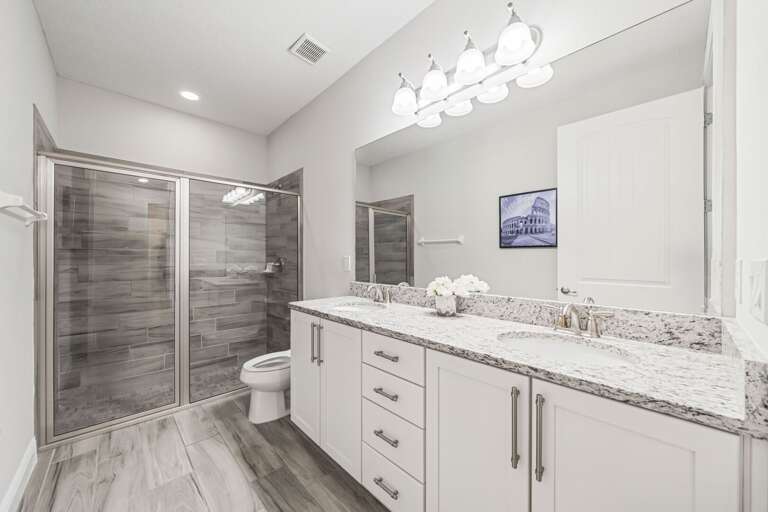 Bathroom with dual sinks and glass enclosed shower Bathroom with dual sinks and glass enclosed shower