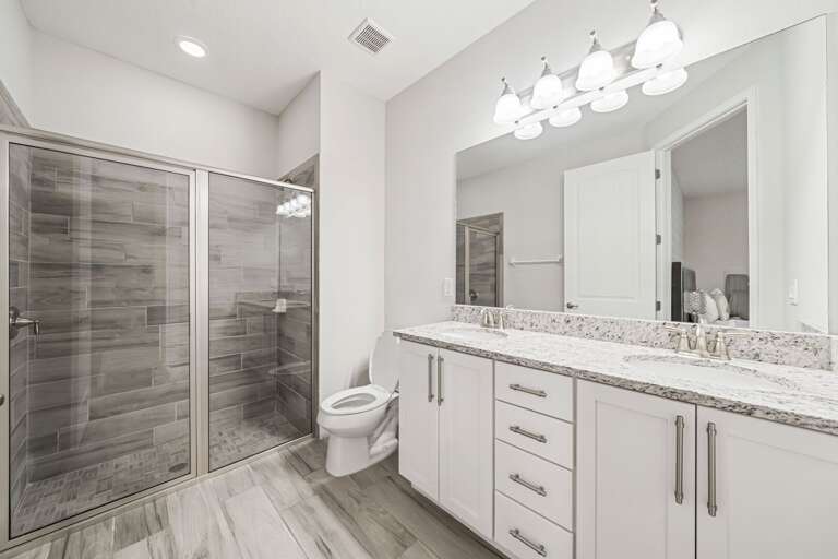 Bathroom with dual sinks and glass enclosed shower Bathroom with dual sinks and glass enclosed shower