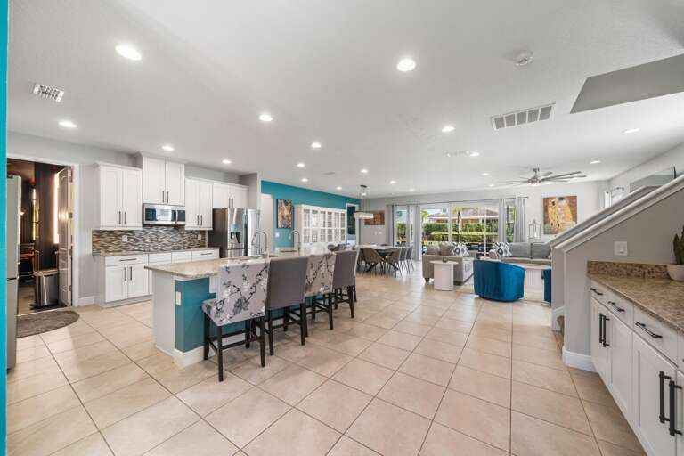 - Bright kitchen with large dining table.
- Modern kitchen island with seating.
- Spacious open kitchen and dining area.