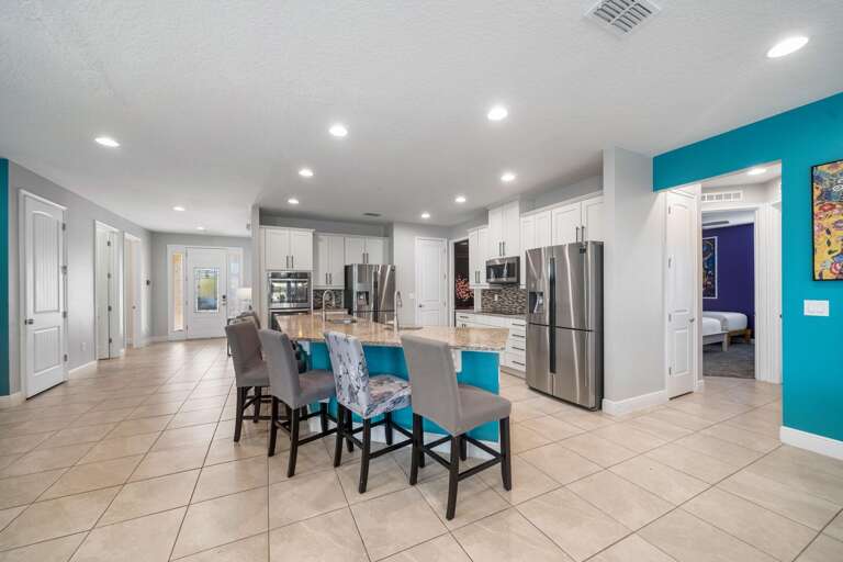 - Bright kitchen with large dining table.
- Modern kitchen island with seating.
- Spacious open kitchen and dining area.